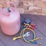 Refrigerant tank and pressure gauge set for HVAC maintenance with color-coded hoses, used by PAC Plumbing and HVAC services.