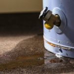 Corroded water heater with valve, leaking water on floor; PAC Plumbing maintenance alert.