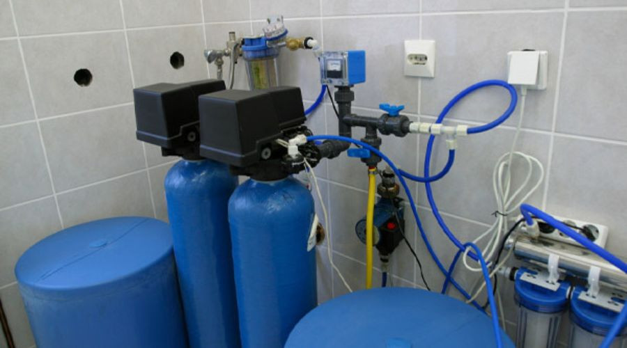 Blue water filtration tanks with piping and valves for enhancing water safety by PAC Plumbing, Heating, and Air Conditioning.